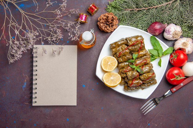 Top view delicious leaf dolma with lemon slices on the dark background meat dish leaf dinner meal food