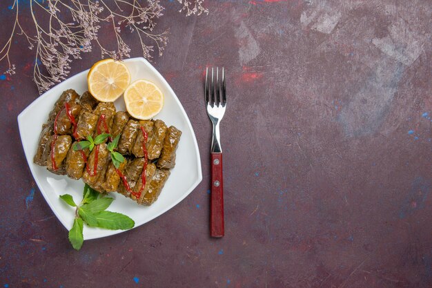 Top view delicious leaf dolma with lemon slices on dark background meat dish leaf food dinner meal