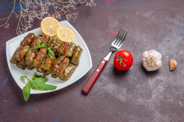 Top view delicious leaf dolma with lemon slices on the dark background meat dish leaf food dinner meal