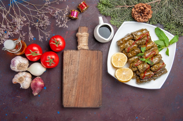 Top view delicious leaf dolma with lemon slices on dark floor meat dish leaf dinner meal food