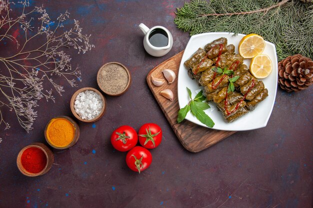 Top view delicious leaf dolma with lemon slices and seasonings on a dark background meal dish leaf meat dinner food