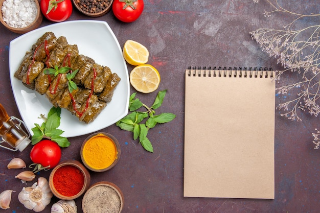 Top view delicious leaf dolma with seasonings and tomatoes on the dark background dish leaf food meat dinner