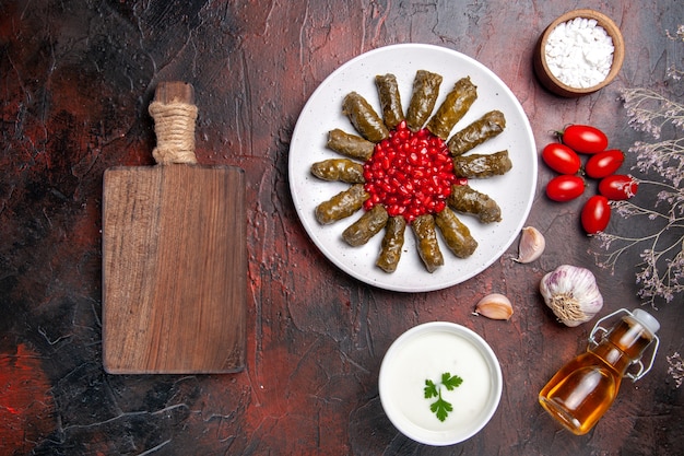 Foto gratuita vista dall'alto della deliziosa foglia dolma con yogurt sulla superficie scura