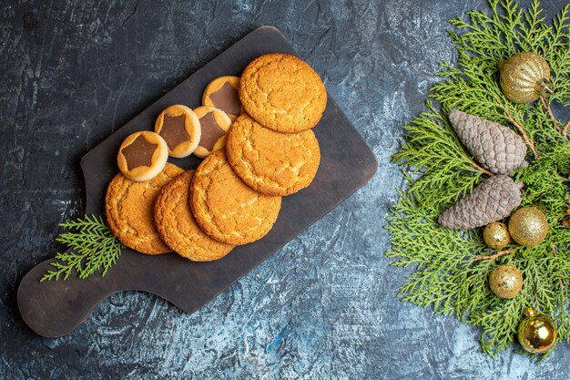 Вид сверху вкусное маленькое печенье с игрушками и зеленой веткой