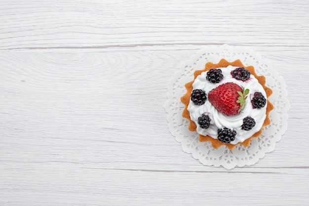 Vista dall'alto di deliziosa piccola torta con crema e frutti di bosco su bianco, torta biscotto cuocere frutta dolce zucchero berry