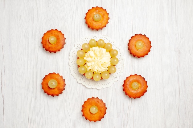 Top view delicious little cakes perfect sweets for tea lined on white desk cake pie sweet dessert tea