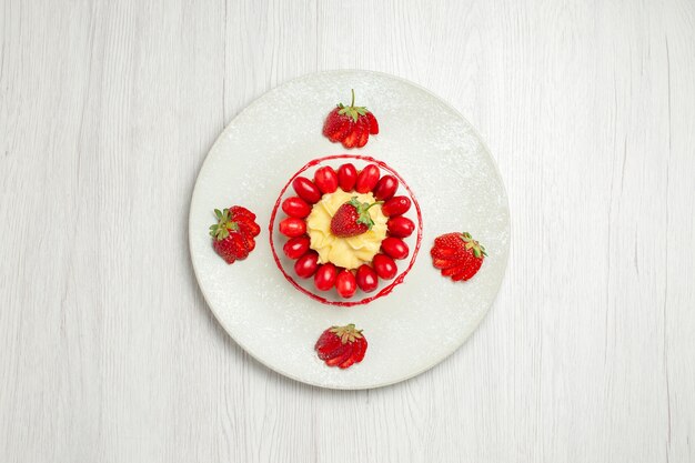 Top view delicious little cakes with fruits on light-white desk