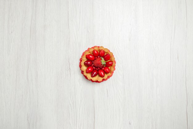 Top view delicious little cakes with fruits on a white desk