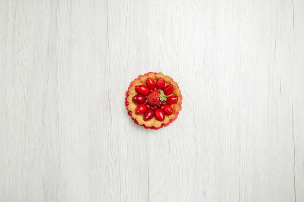 Вид сверху вкусные маленькие пирожные с фруктами на белом столе