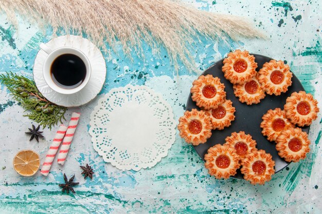 Top view delicious little cookies with bagels and cup of coffee on blue desk cookie biscuit sweet sugar color