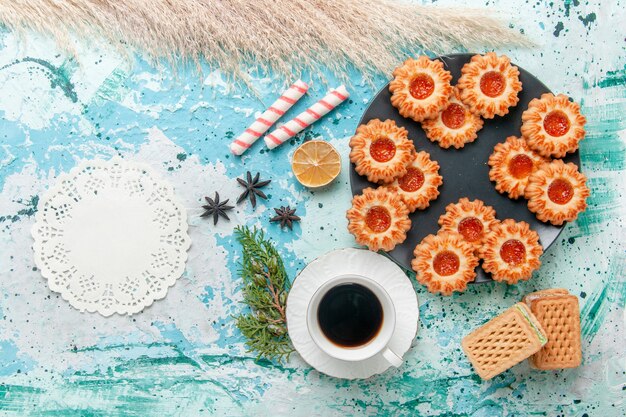 Top view delicious little cookies with cup of coffee and waffles on the blue desk cookie biscuit sweet sugar color tea