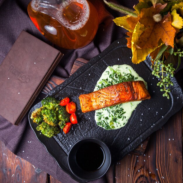 Top view delicious meal in black tray on dark wooden background with decorations
