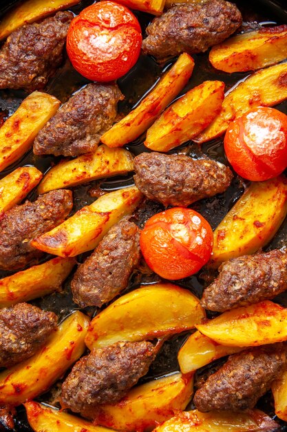 Top view of delicious meat cutlets baked with potatoes and tomatoes