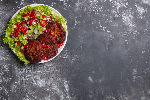 Vista dall'alto deliziose cotolette di carne con insalata fresca