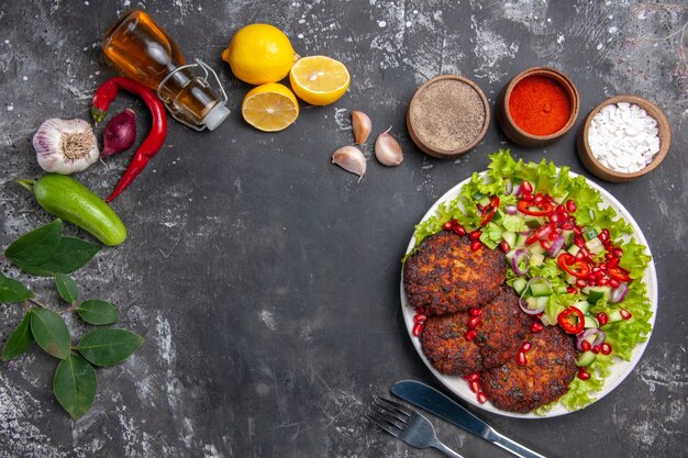 Вид сверху вкусные мясные котлеты со свежим салатом