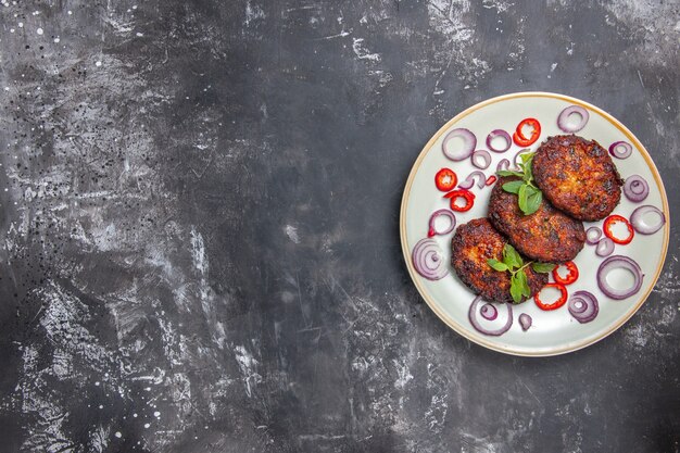 Free photo top view delicious meat cutlets with onion rings