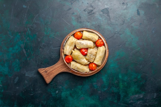 Вид сверху вкусной мясной еды, завернутой в капусту с помидорами на темно-синем столе, мясная еда, ужин, калорий, овощное блюдо, приготовление