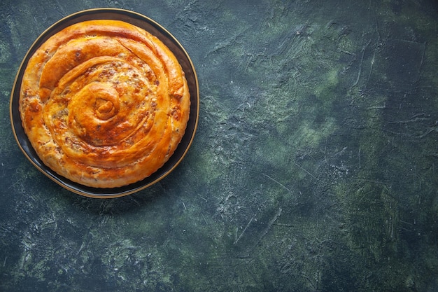 Top view of delicious meat pie on dark surface