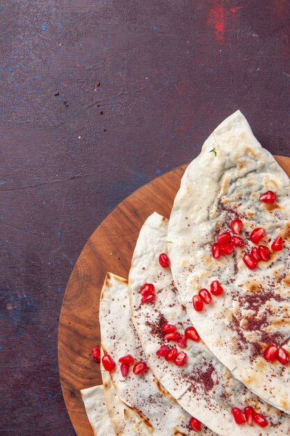 어두운 보라색 책상 고기 반죽 식사 피타에 신선한 붉은 석류와 상위 뷰 맛있는 고기 qutabs pitas