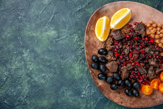 top view delicious meat slices fried with beans grapes and lemon slices inside plate, meal food fruit meat