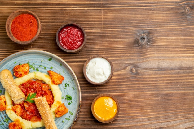 Foto gratuita vista dall'alto deliziose fette di carne con purè di patate e condimenti su piatto da scrivania marrone farina di carne patate pane cibo