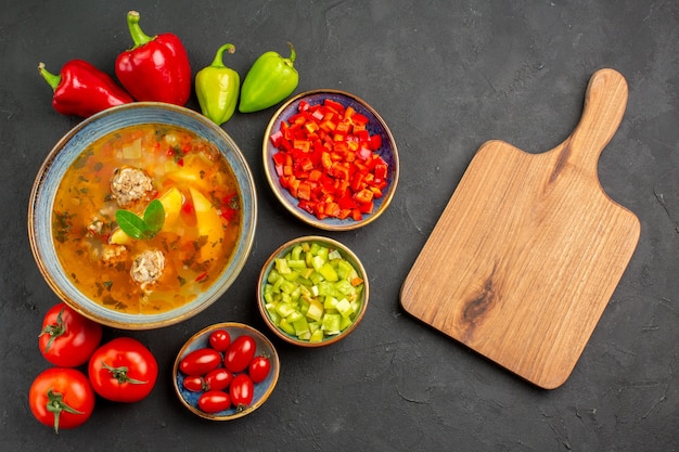 暗い床の皿の写真の食事の食糧の新鮮な野菜が付いている上面図のおいしい肉のスープ