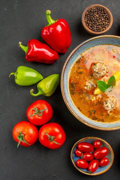暗いテーブル皿の写真の食べ物に新鮮な野菜とおいしい肉のスープを上から見る