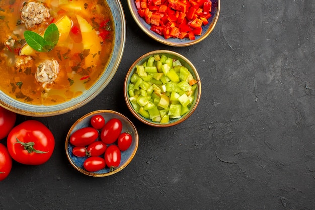 暗いテーブルの皿の写真の食事の食糧の新鮮な野菜が付いている上面図のおいしい肉のスープ