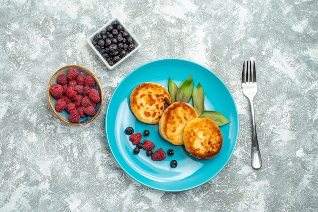 Top view delicious muffins with berries on light background