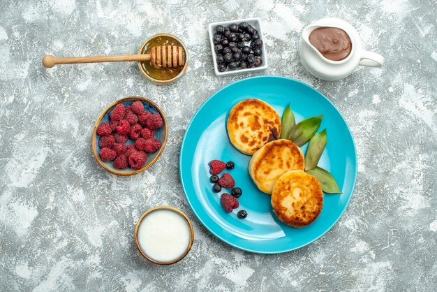 Вид сверху вкусные кексы с ягодами на светлом фоне