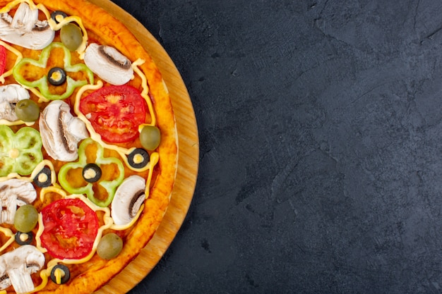 Top view delicious mushroom pizza with red tomatoes bell-peppers olives and mushrooms all sliced inside on the dark desk food meal pizza