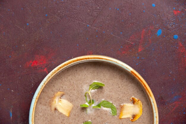 Top view delicious mushroom soup inside plate on dark desk