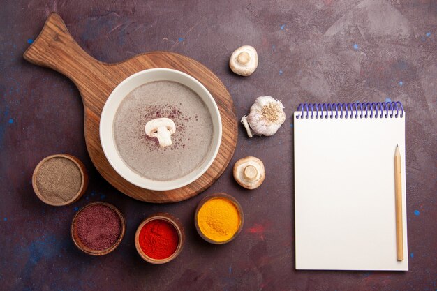 Top view delicious mushroom soup with seasonings on dark desk