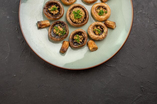 Top view delicious mushrooms meal cooked with greens inside plate on dark desk dish dinner ripe meal cooking wild