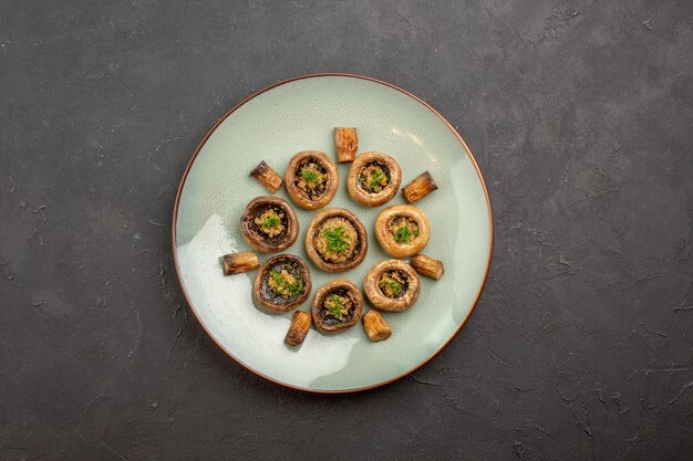 Top view delicious mushrooms meal cooked with greens inside plate on a dark surface dish dinner wild ripe meal cooking