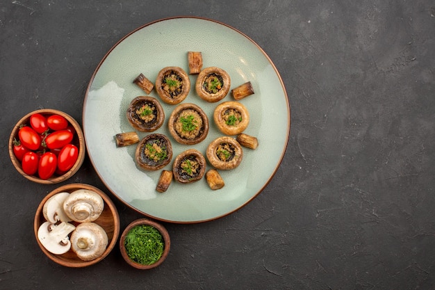 Бесплатное фото Вид сверху вкусной грибной еды со свежей зеленью и помидорами на темной поверхности блюдо ужин еда приготовление грибов