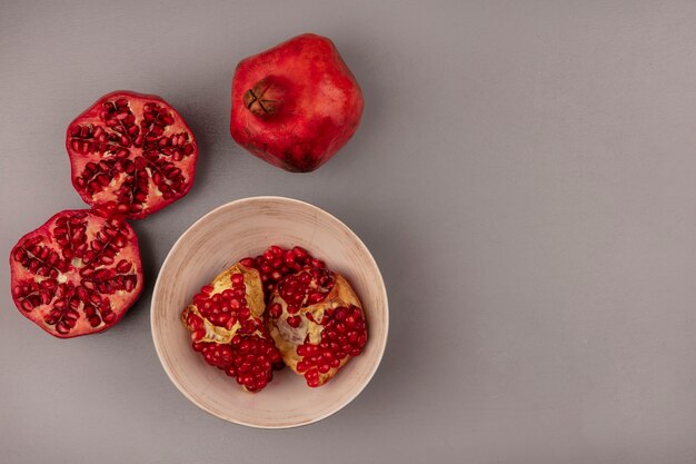 Top view of delicious open pomegranates with seeds on a bowl with copy space