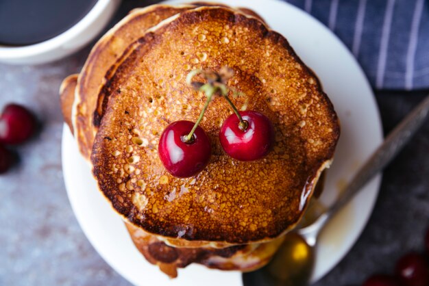 Top view delicious pancakes and cherries breakfast