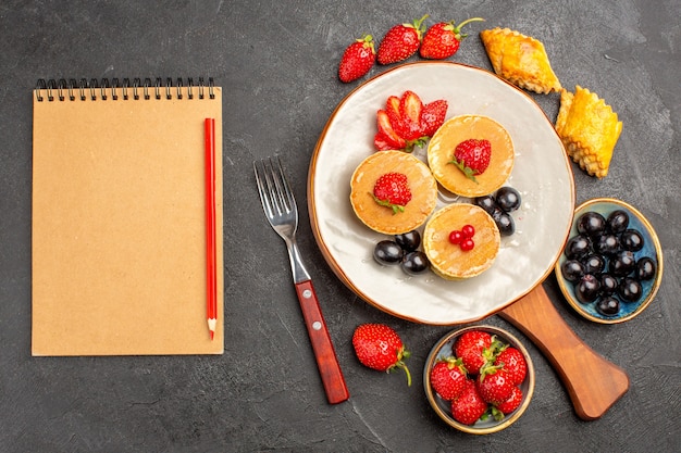 Top view delicious pancakes with fruits on dark surface pie fruit cake sweet