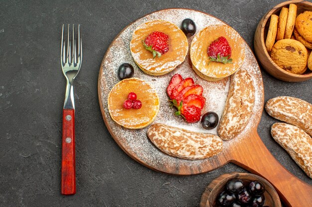 Top view delicious pancakes with fruits and sweet cakes on dark floor cake dessert sweet