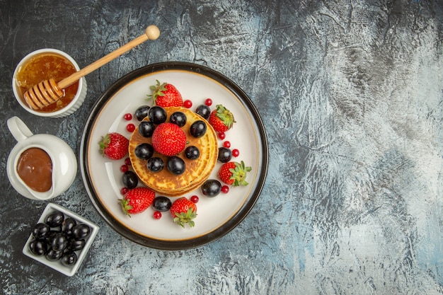 달콤한 가벼운 표면 과일 케이크에 꿀과 과일 상위 뷰 맛있는 팬케이크