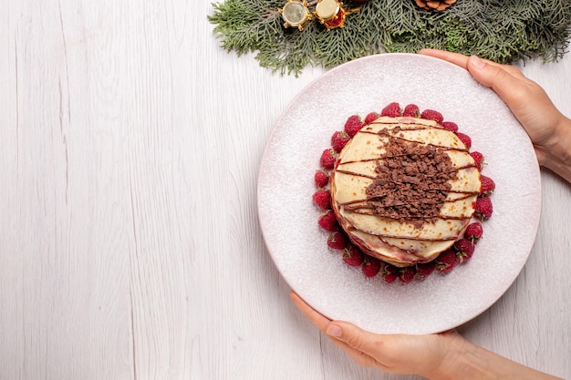 Foto gratuita vista dall'alto deliziose frittelle con fragole su torta bianca torta di frutta biscotto torta di bacche