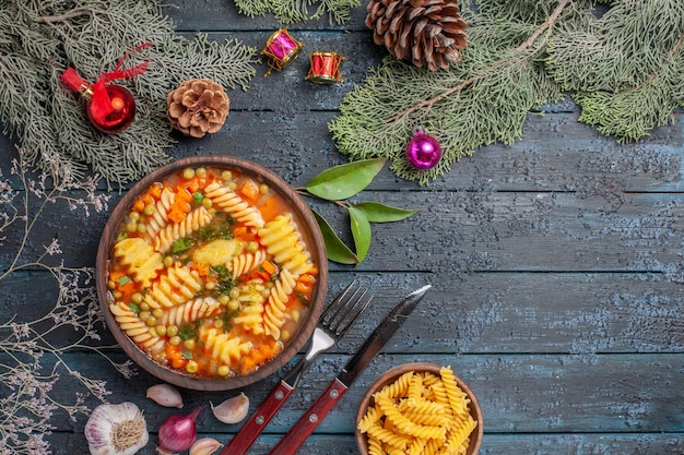 Vista dall'alto deliziosa zuppa di pasta dalla pasta italiana a spirale sul piatto da tavolo blu scuro cucina zuppa di colore pasta