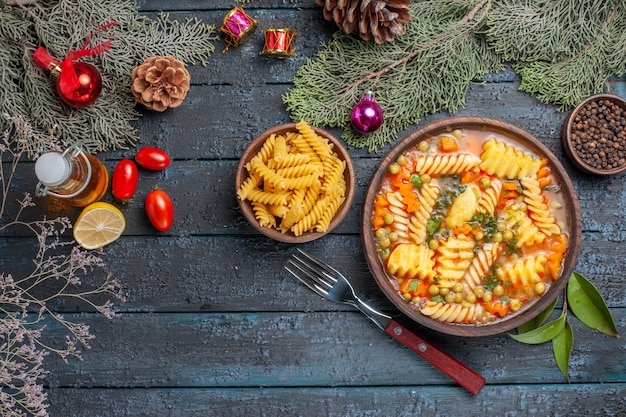 Вид сверху вкусной пасты, суп из спиральной итальянской пасты на темно-синем столе, блюдо, кухня, цветной суп, паста