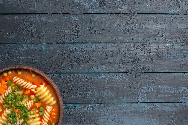 Top view delicious pasta soup with greens and vegetables inside plate on dark background dish italian pasta soup meal dinner