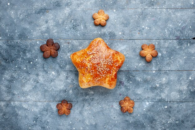 Top view of delicious pastry star shaped with cookies on grey, sweet bake pastry sugar cake