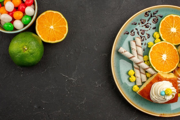 Foto gratuita vista dall'alto deliziose fette di torta con biscotti da pipa e mandarini freschi a fette su uno sfondo scuro torta di frutta torta biscotto dolce