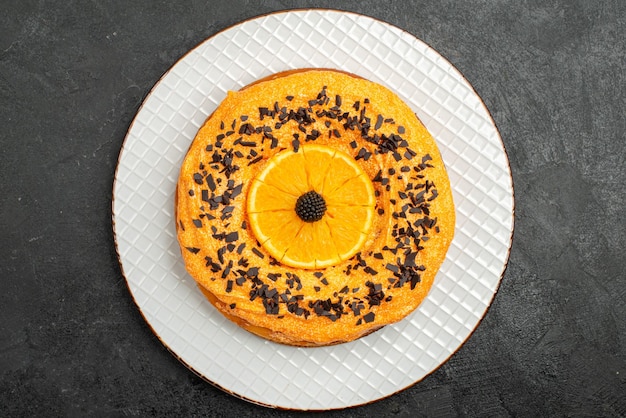 Вид сверху вкусный пирог с шоколадной стружкой и дольками апельсина на темной поверхности пирог десертный торт чай фруктовый бисквит