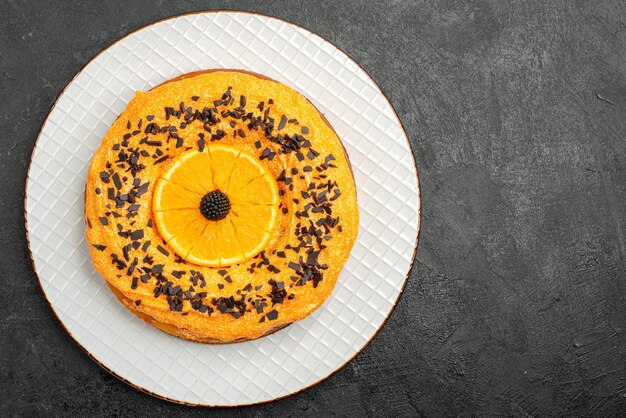 暗い表面のパイデザートケーキティーフルーツビスケットにチョコレートチップとオレンジスライスが付いた上面図のおいしいパイ