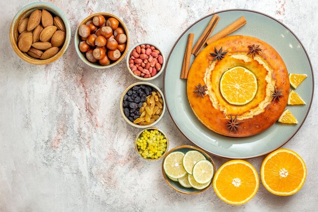 Top view delicious pie with nuts and citrus fruits on white background fruits sweet nut cake pie biscuit